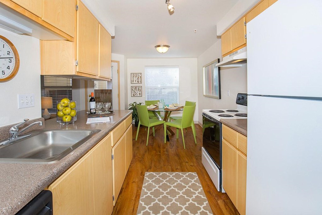 a kitchen with wooden cabinets and a table with green chairs